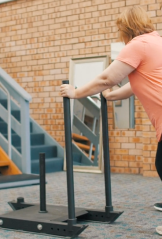 a lady pushing a weighted trolley to test her work ability